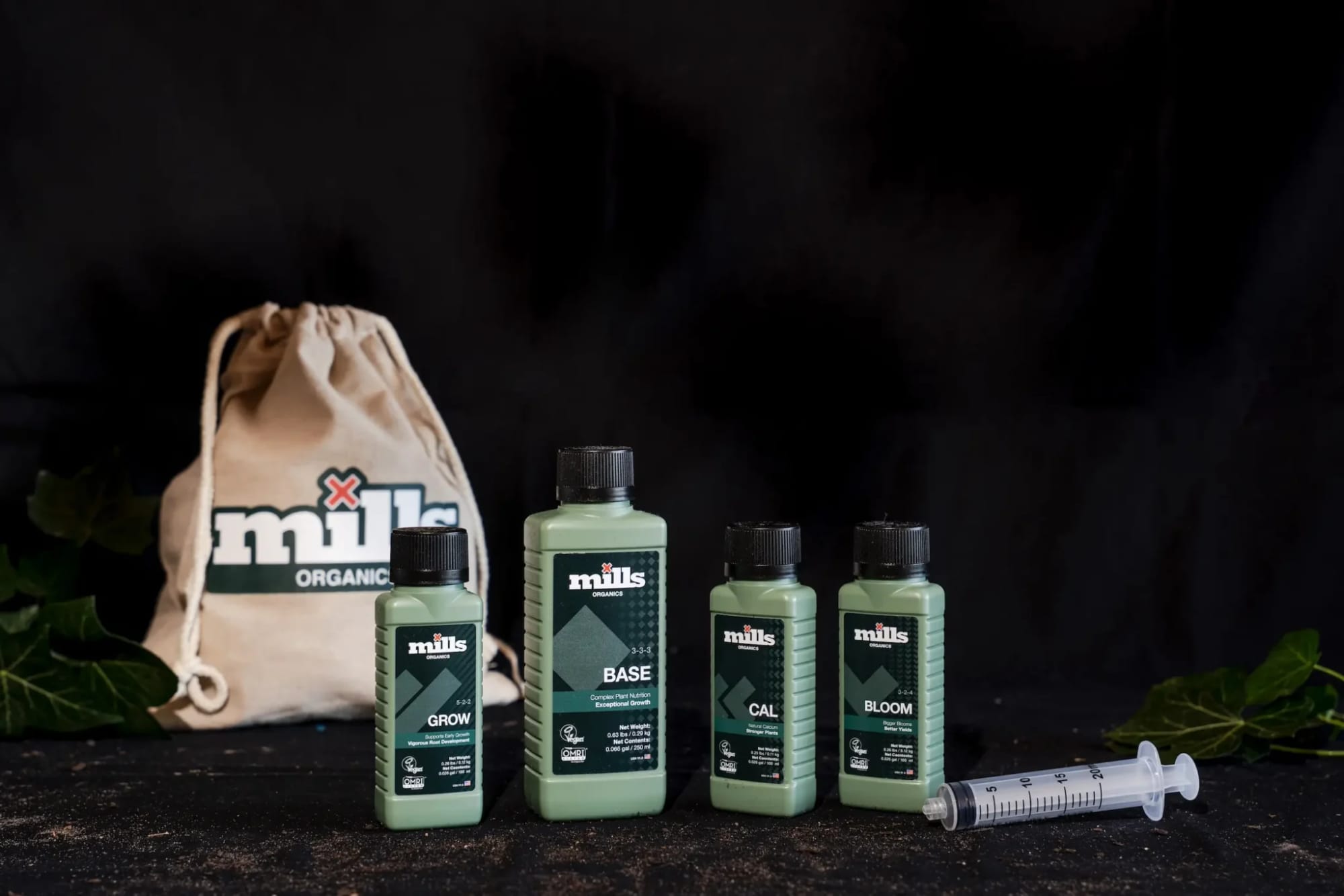 Mills Organics Grow, Base, CAL and Bloom bottles beside a Mills Organics bag